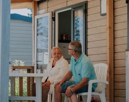 retraité assis sur la terrasse d'un mobil-home dans un camping chadotel.