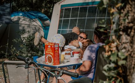 famille qui prend son petit déjeuner à l'extérieur de leur toile de tente dans un camping chadotel.